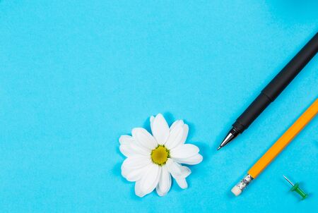 Different office supplies and tablet with a phone for work and education on a blue background