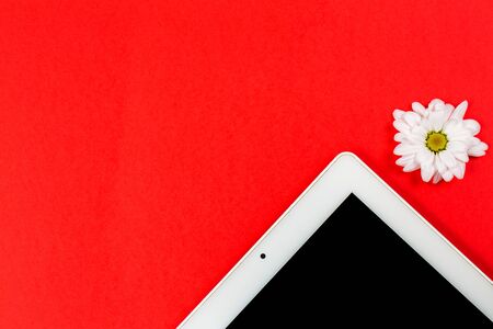 Various stationery and tablet with a phone for work and study and a cup of coffee on a red backgroundの写真素材