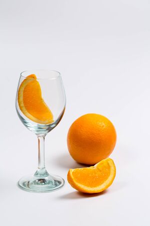 Fresh oranges in a glass cup on a white backgroundの写真素材