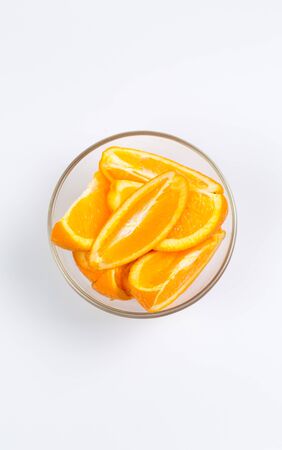 Fresh oranges in a glass cup on a white backgroundの写真素材