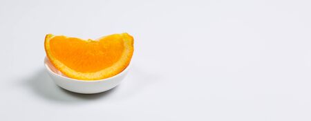 Fresh oranges in a glass cup on a white backgroundの写真素材