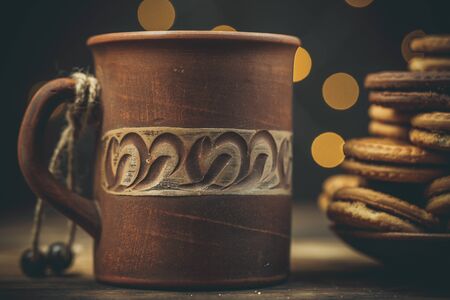 Round sweet cookies and a cup of tea on a wooden table in vintage styleの写真素材