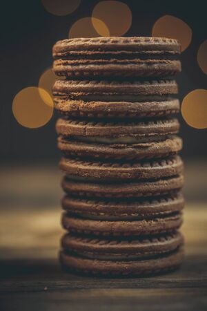 Round sweet cookies and a cup of tea on a wooden table in vintage styleの写真素材