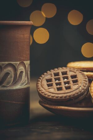 Round sweet cookies and a cup of tea on a wooden table in vintage styleの写真素材