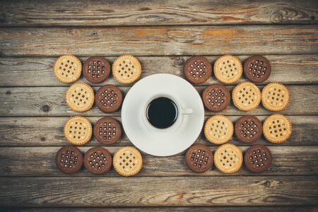 Vanilla and chocolate chip cookies and aromatic coffee on a wooden backgroundの写真素材