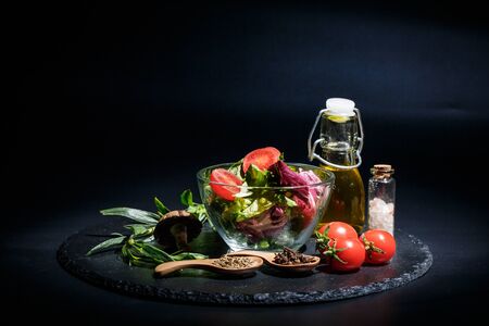 Vegetables for diet, different spices on a black backgroundの写真素材