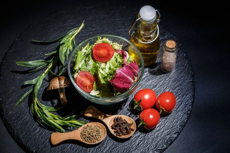 Vegetables for diet, different spices on a black backgroundの写真素材
