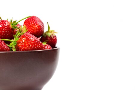 Strawberries on a brown plate on a white backgroundの写真素材