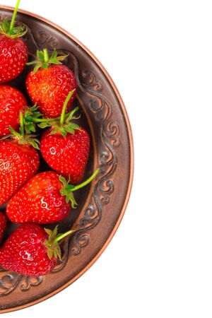 Strawberries on a brown plate on a white backgroundの写真素材
