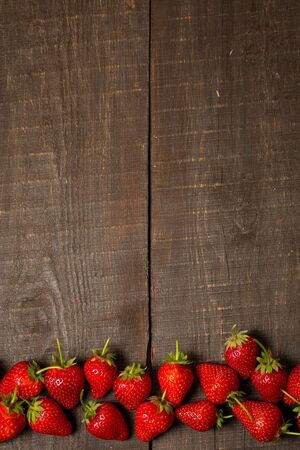 Ripe red strawberries on a brown wooden backgroundの写真素材