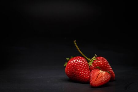 Ripe red strawberries on a black backgroundの写真素材