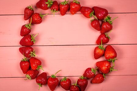 Ripe red strawberries on a pink wooden backgroundの写真素材