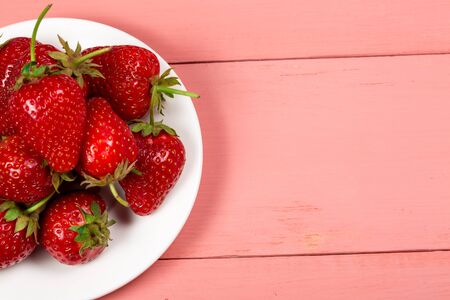 Ripe red strawberries on a pink wooden backgroundの写真素材