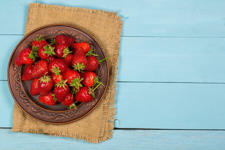 Ripe red strawberries on a blue wooden backgroundの写真素材
