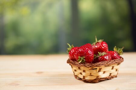 Ripe strawberries in a basket on the tableの写真素材
