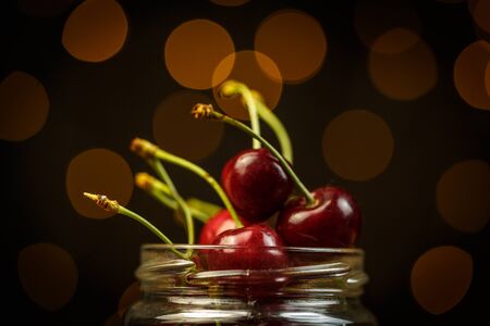 Ripe cherries on a brown table, beautiful bokehの写真素材