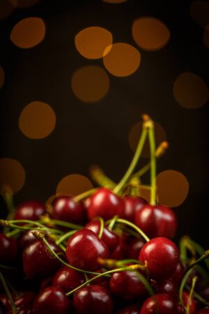 Ripe cherries on a brown table, beautiful bokehの写真素材