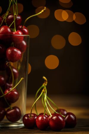 Ripe cherries on a brown table, beautiful bokehの写真素材