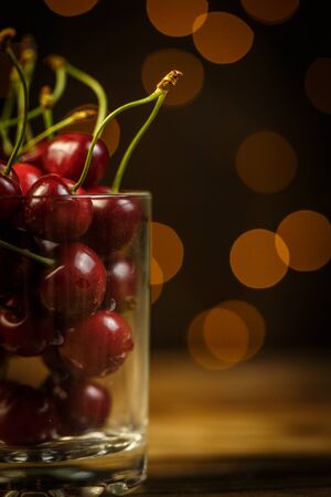 Ripe cherries on a brown table, beautiful bokehの写真素材