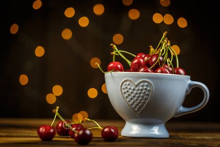 Ripe cherries on a brown table, beautiful bokehの写真素材