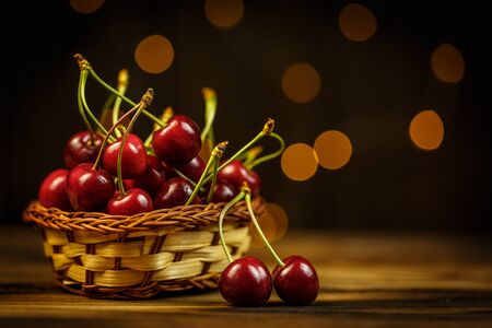 Ripe cherries on a brown table, beautiful bokehの写真素材