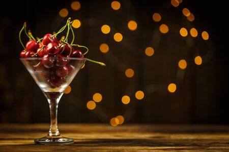 Ripe cherries on a brown table, beautiful bokehの写真素材