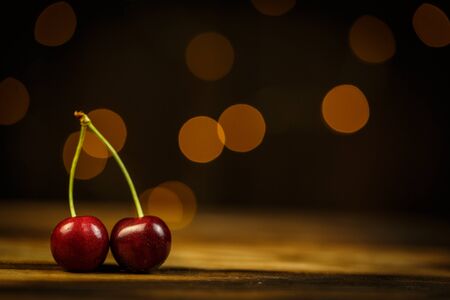 Ripe cherries on a brown table, beautiful bokehの写真素材