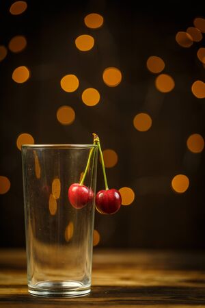 Ripe cherries on a brown table, beautiful bokehの写真素材