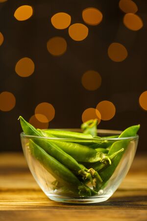 Ripe peas on a wooden table, beautiful bokeh