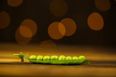 Ripe peas on a wooden table, beautiful bokehの写真素材