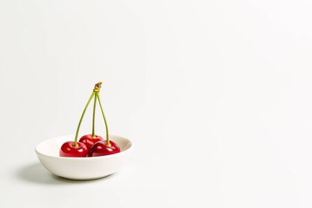 Ripe, red, sweet cherries on a white backgroundの写真素材