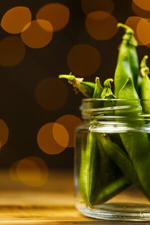 Ripe peas on a wooden table, beautiful bokehの写真素材