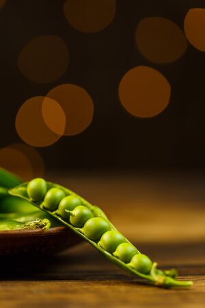 Ripe peas on a wooden table, beautiful bokehの写真素材