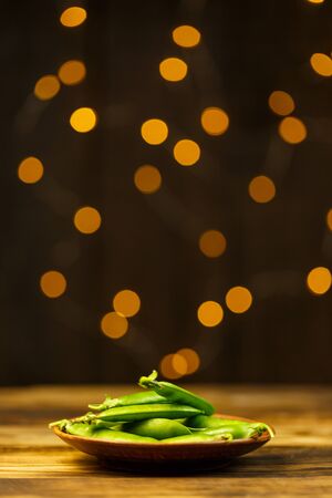 Ripe peas on a wooden table, beautiful bokehの写真素材