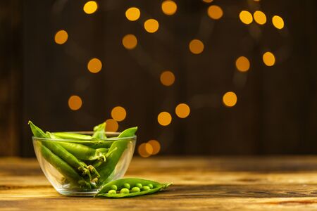 Ripe peas on a wooden table, beautiful bokehの写真素材