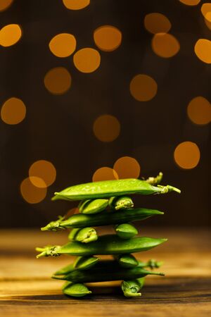 Ripe peas on a wooden table, beautiful bokehの写真素材