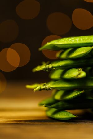 Ripe peas on a wooden table, beautiful bokehの写真素材