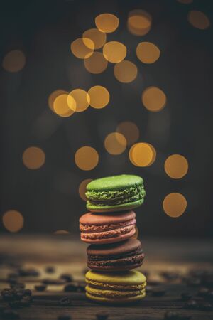 Tasty macaroon cookies with coffee on a wooden table in warm color with beautiful bokehの写真素材
