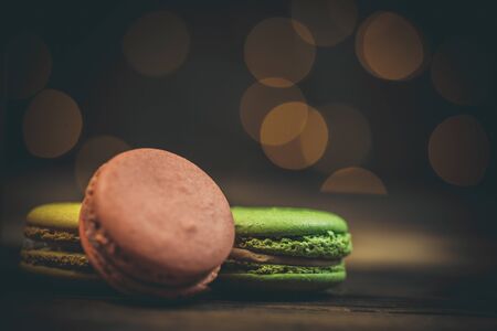 Tasty macaroon cookies with coffee on a wooden table in warm color with beautiful bokehの写真素材