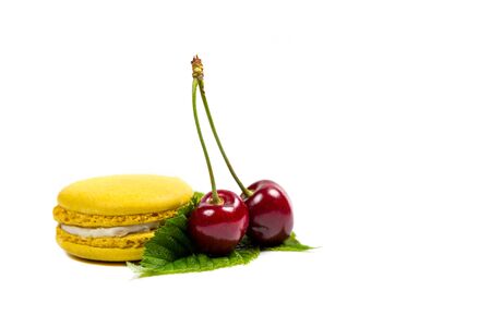 Tasty macaroon cookies and red cherries on a white backgroundの写真素材