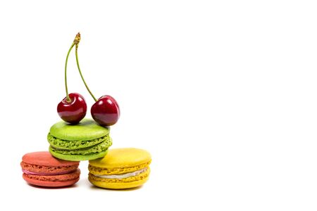 Tasty macaroon cookies and red cherries on a white backgroundの写真素材