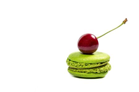 Tasty macaroon cookies and red cherries on a white backgroundの写真素材