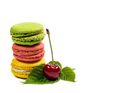Tasty macaroon cookies and red cherries on a white backgroundの写真素材