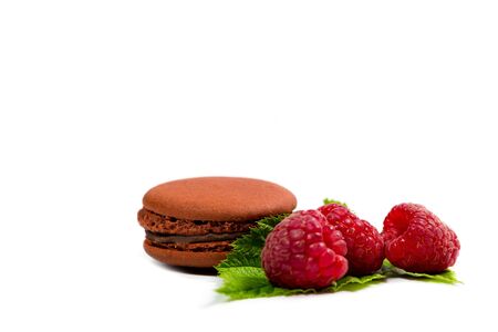 Tasty macaroon cookies and ripe raspberries on a white backgroundの写真素材