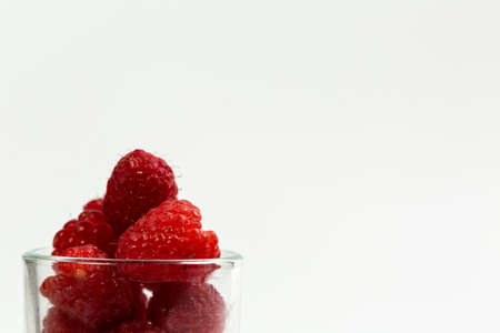 Fresh and red raspberries with vitamins on a white backgroundの写真素材