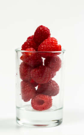 Fresh and red raspberries with vitamins on a white backgroundの写真素材