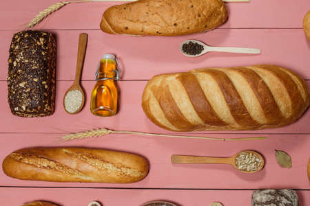 Assorted loaves of fresh gluten free bread on pink background