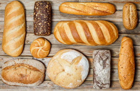 Gluten-free fresh bread of different colors and shapes on wooden surfaceの写真素材