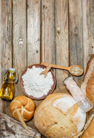 Gluten-free fresh bread of different colors and shapes on wooden surfaceの写真素材