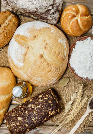 Gluten-free fresh bread of different colors and shapes on wooden surfaceの写真素材